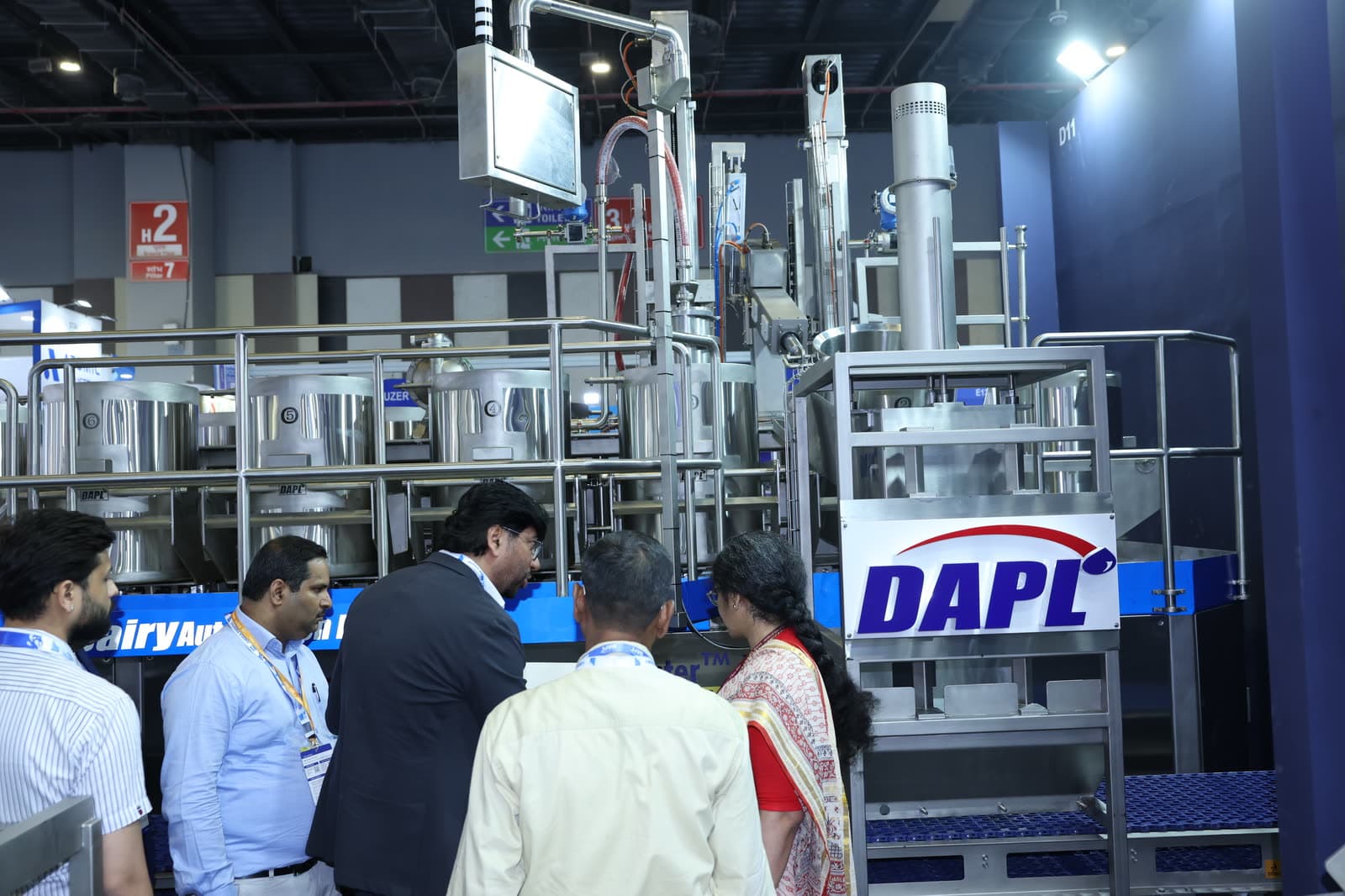 Delegates inspecting dairy processing machinery on the floor