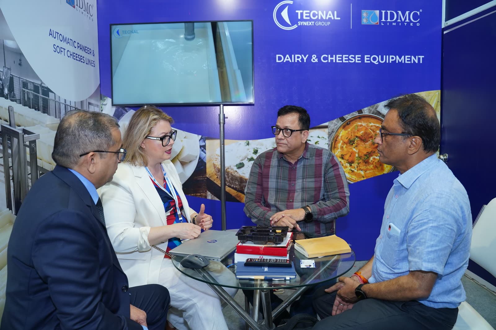 Business conversation at a dairy and cheese equipment booth