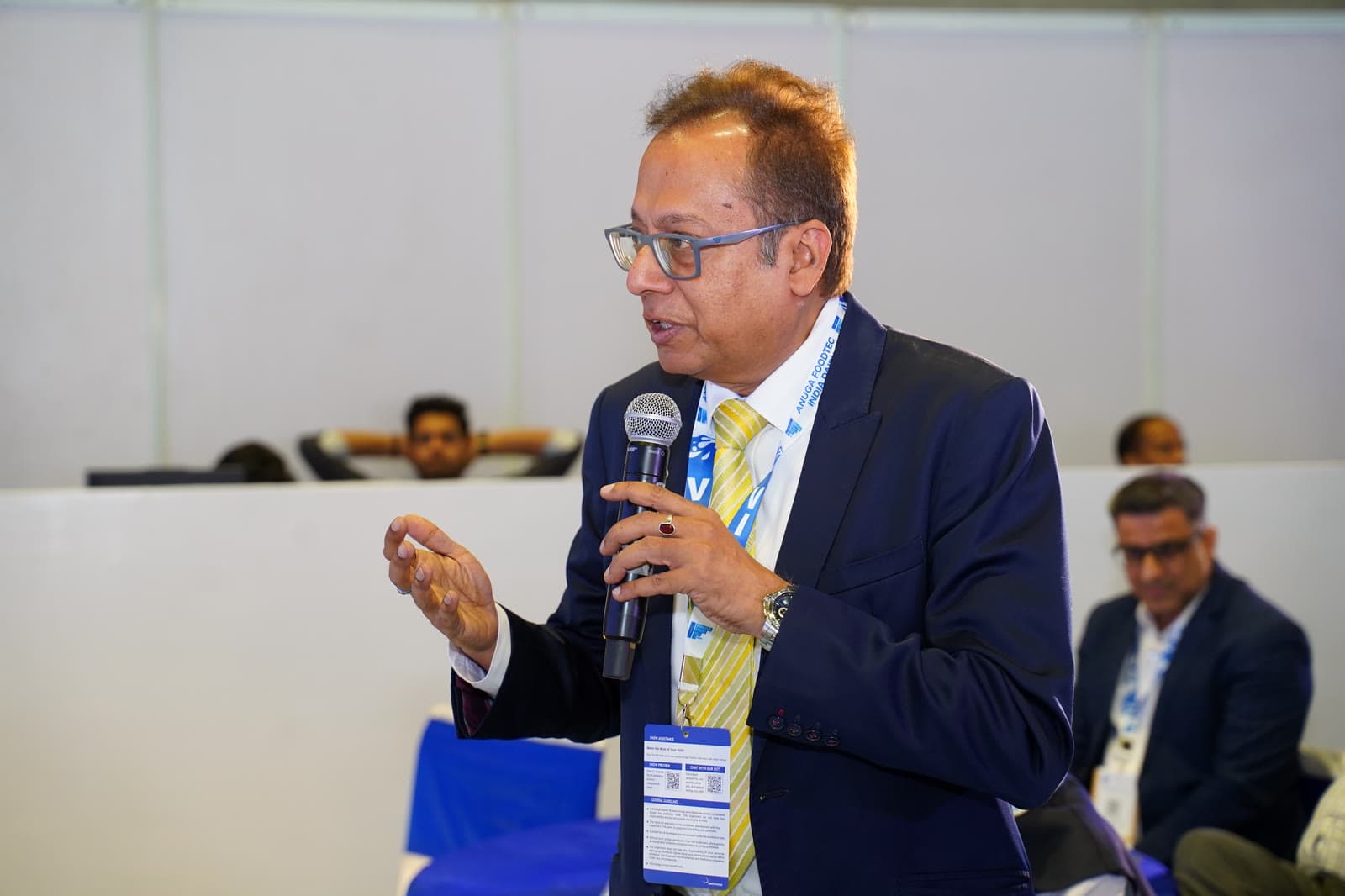 Speaker at conference with microphone, passionate gesture